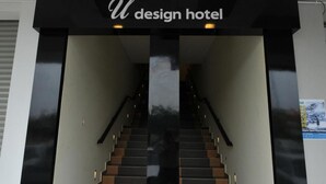 En trappa som leder till hotellentrén, där det finns en skylt med texten ”U design hotel”.