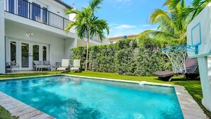 A swimming pool with a basketball hoop, surrounded by palm trees and a well-maintained lawn. - Miami Toro: Private Pool, Pool Table, & Near Beach (Miami)