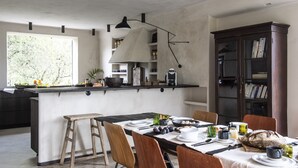 Een moderne keuken met een centraal eiland, houten stoelen en een eettafel gedekt voor een maaltijd.