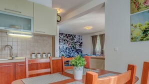 Una cocina moderna con comedor, con armarios de madera, un lavamanos y un reloj en la pared.