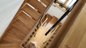 A wooden staircase with a handrail, leading to a higher floor. - Adlernest (Feldberg)