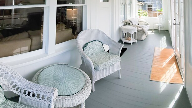 A covered porch with wicker furniture, large windows, and a view of the outside. - Enjoy This 4 Bedroom w/ a Beautiful Yard, Ocean Views and Easy Beach Access! (Seaside)