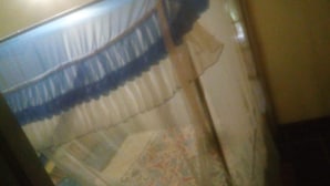 A room with a bed covered by a patterned bedspread and a blue and white canopy. - Flo Garden Resort (Ruiru)