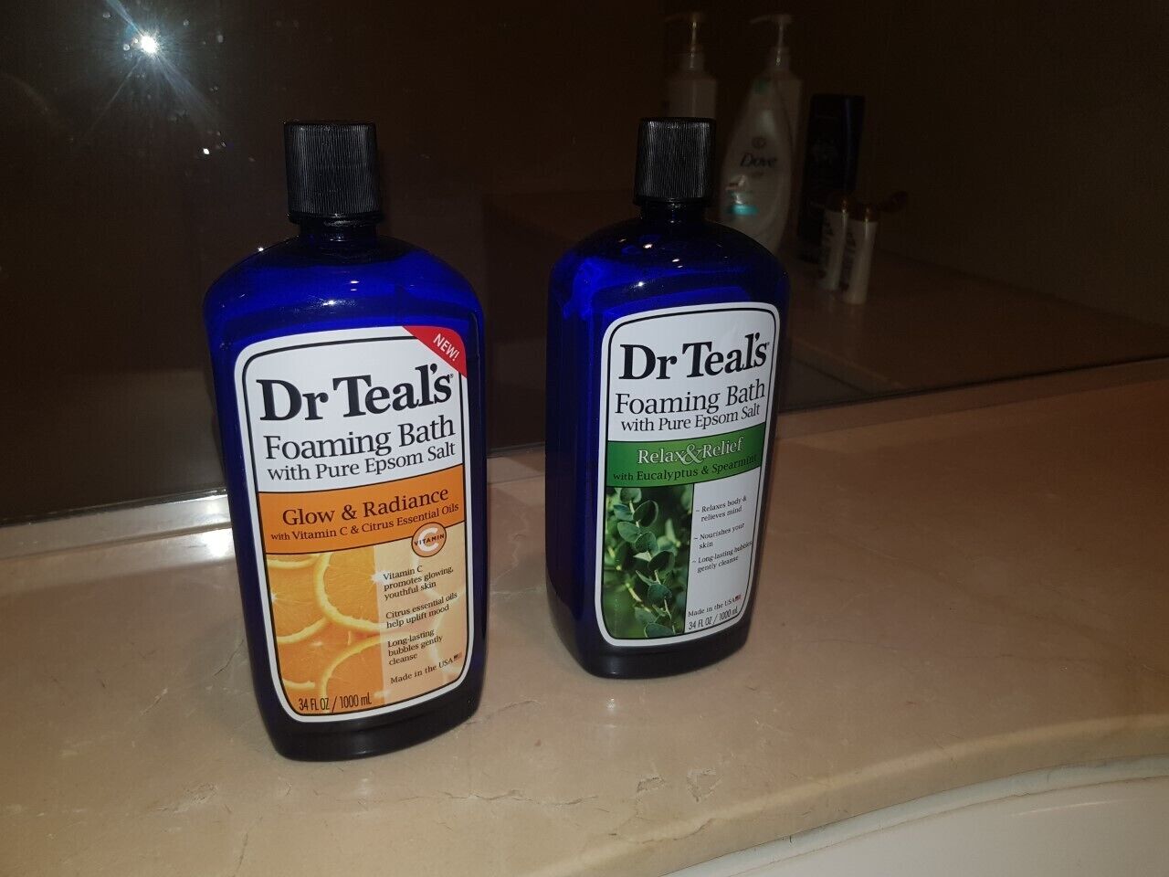 Two bottles of Dr. Teal's Bath Foaming Bath with Pure Epsom Salt on a countertop.