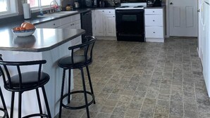 A modern kitchen with white cabinets, a black stove, and a granite countertop. - Lovely house on the Snake River that is minutes from CJ Strike Reservoir ! (Bruneau)