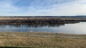 A calm river with a grassy bank and distant hills. - Lovely house on the Snake River that is minutes from CJ Strike Reservoir ! (Bruneau)