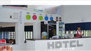 A hotel reception area with a counter, clocks displaying different time zones, and a sign for 'HOTEL PORTO BELO'. - Hotel Porto Bello (Caico)