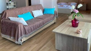 A modern living room with a sofa, a coffee table, and a bed.