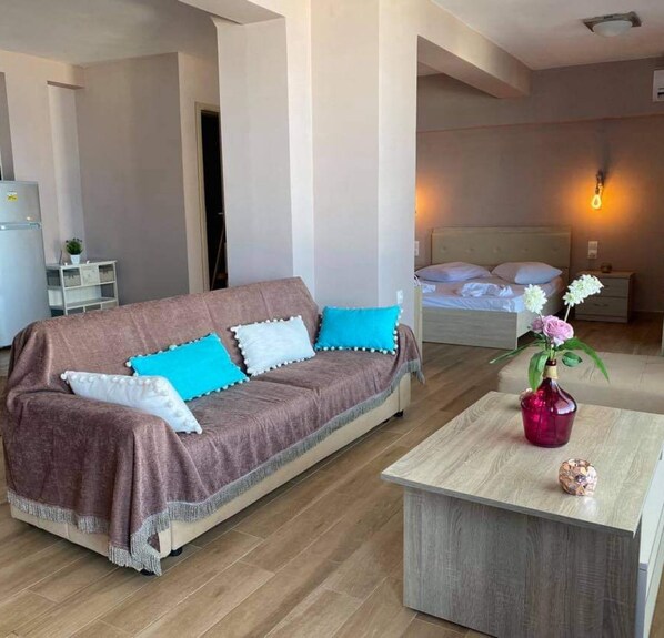 A modern living room with a sofa, a coffee table, and a bed.