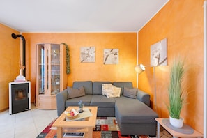 Un salon comprenant un canapé, une petite table, un meuble et une cheminée.