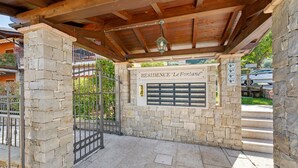 A stone building with a wooden roof and a metal gate.