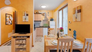 A compact living space with a kitchen, dining area, and a TV.
