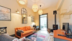 A cozy living room with a sofa, a fireplace, and a television. - The Manor Suite at Moyglare Manor (Maynooth)