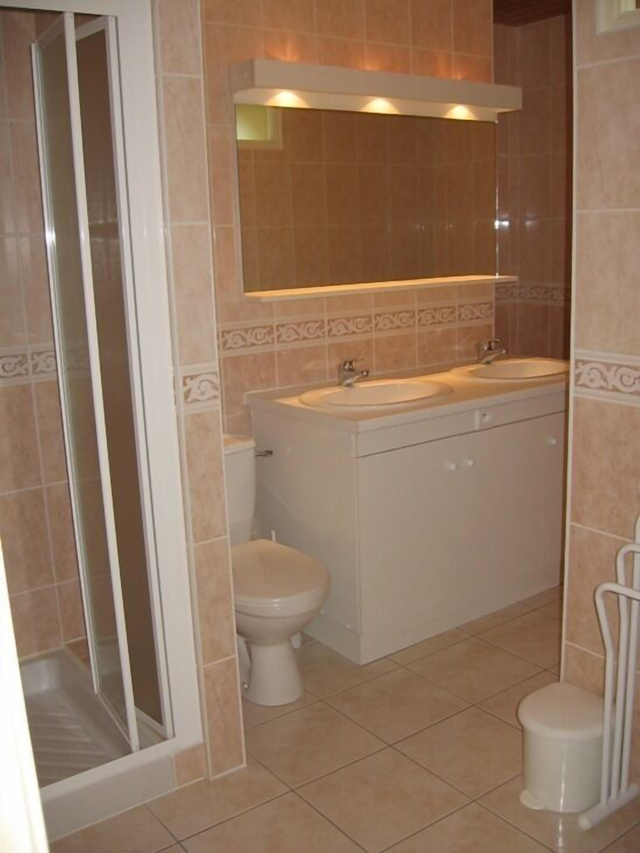 A bathroom with a shower, toilet, and sink.