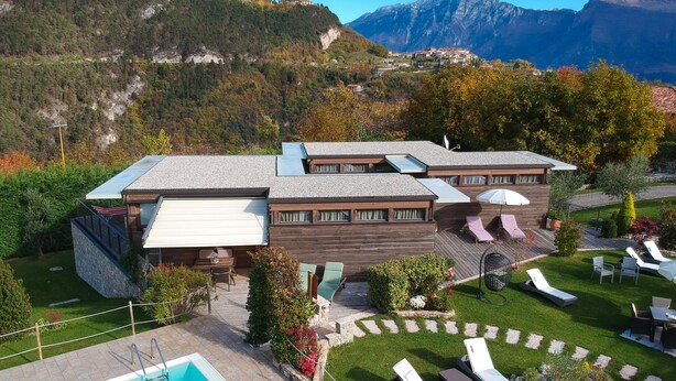 A modern hotel with a pool, lounge chairs, and a mountainous backdrop. - Holiday Apartment "GeoResort B6" with Panoramic Views and Shared Pool (Tremosine)