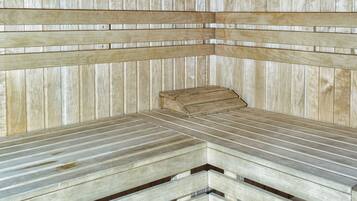 Un sauna avec des bancs en bois et un plafond à lattes.