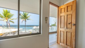 A wooden door leading to a balcony with a view of the sea and palm trees. - Hotel La Fragata Coveñas (Coveñas)