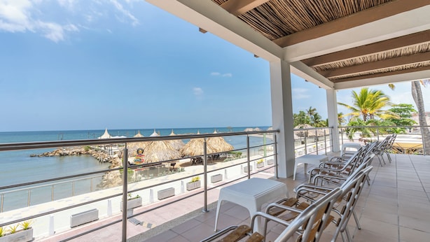 A covered outdoor seating area with a view of the ocean and beach. - Hotel La Fragata Coveñas (Coveñas)