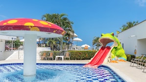 A pool with a slide, a mushroom-shaped umbrella, and a frog-shaped water slide. - Hotel La Fragata Coveñas (Coveñas)