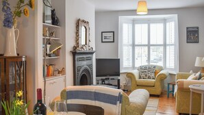 A living room with a fireplace, television, and seating area. - 3 bedroom accommodation in Broadstairs (Broadstairs)