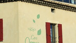 A building with a tiled roof, red shutters, and a sign reading "Les Ormes Chambres d'Hotes". - New in 2020, 5 guest rooms, tastefully decorated, ideal location! (saint remy de provence)