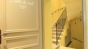 A hallway with a door labeled "La Belle de nuit" leading to a staircase. - New in 2020, 5 guest rooms, tastefully decorated, ideal location! (saint remy de provence)