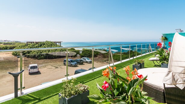 A balcony with a view of the sea, outdoor seating, and potted plants. - Modern, with roof terrace and very close to the beach - Apartamento Caviar (Conil de la Frontera)