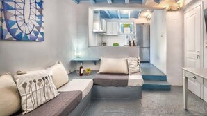 Un espace de vie compact comprenant un coin cuisine, un ensemble de canapés et un coin repas.