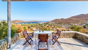 Une terrasse avec une table et des chaises donnant sur un paysage pittoresque.