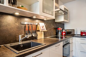 A modern kitchen with a stainless steel sink, a coffee maker, and a toaster.