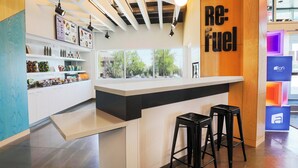 Un espace bar moderne doté d’un comptoir, de tabourets et offrant une vue sur l’extérieur.