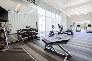 A gym with exercise equipment, a bench, and a mirrored wall. - Aloft by Marriott Reno-Tahoe International Airport (Reno)