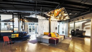 Un hall d’entrée moderne avec un canapé, des fauteuils et un comptoir d’accueil.
