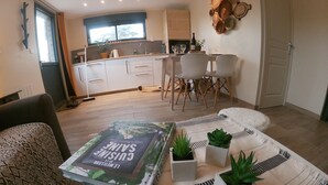 Una sala de estar moderna con un sofá, una mesa baja con una revista y plantas en macetas.