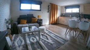 Una sala moderna con sofá, mesa de centro y vista a la cocina.