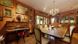 A dining room with a piano, dining table, chairs, and a chandelier. - Apartment 'Baumannhof Hasental - Adults Only' with Mountain View, Shared Garden and Wi-Fi (Gfrill/Tisens bei Lana)