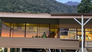 Un hotel con un espacio exterior cubierto, una escalera y vistas a la montaña.