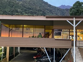 A hotel with a covered outdoor area, a staircase, and a view of a mountain.