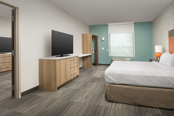 A hotel room with a bed, a TV, a wardrobe, and a window with a view.