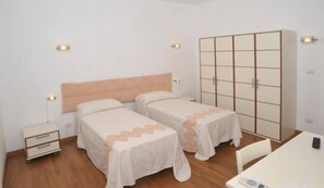 A room with two single beds, a wardrobe, a desk, and a chair. - The Whale B&B (Alghero)