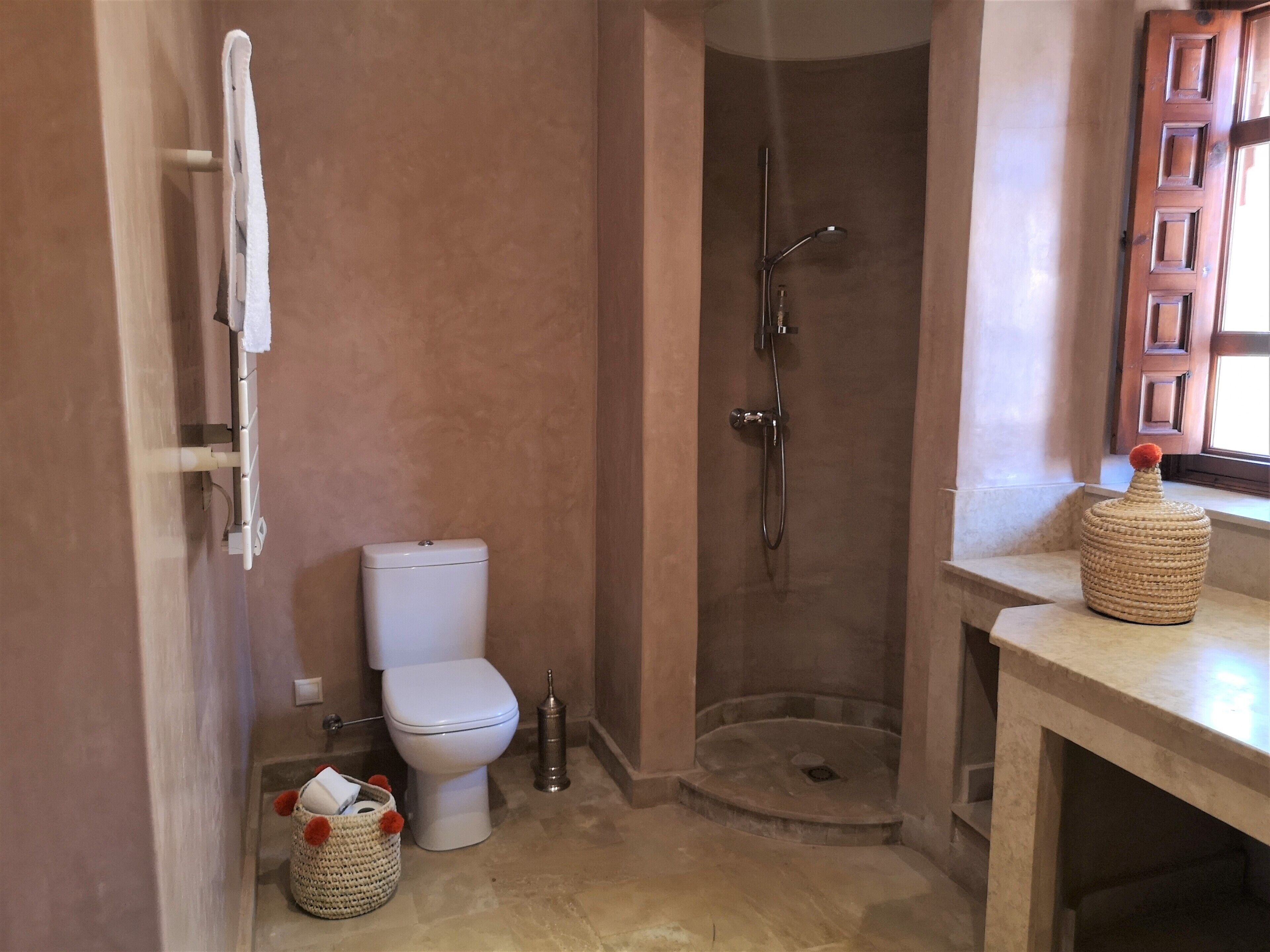 A bathroom with a toilet, a shower, and a sink.