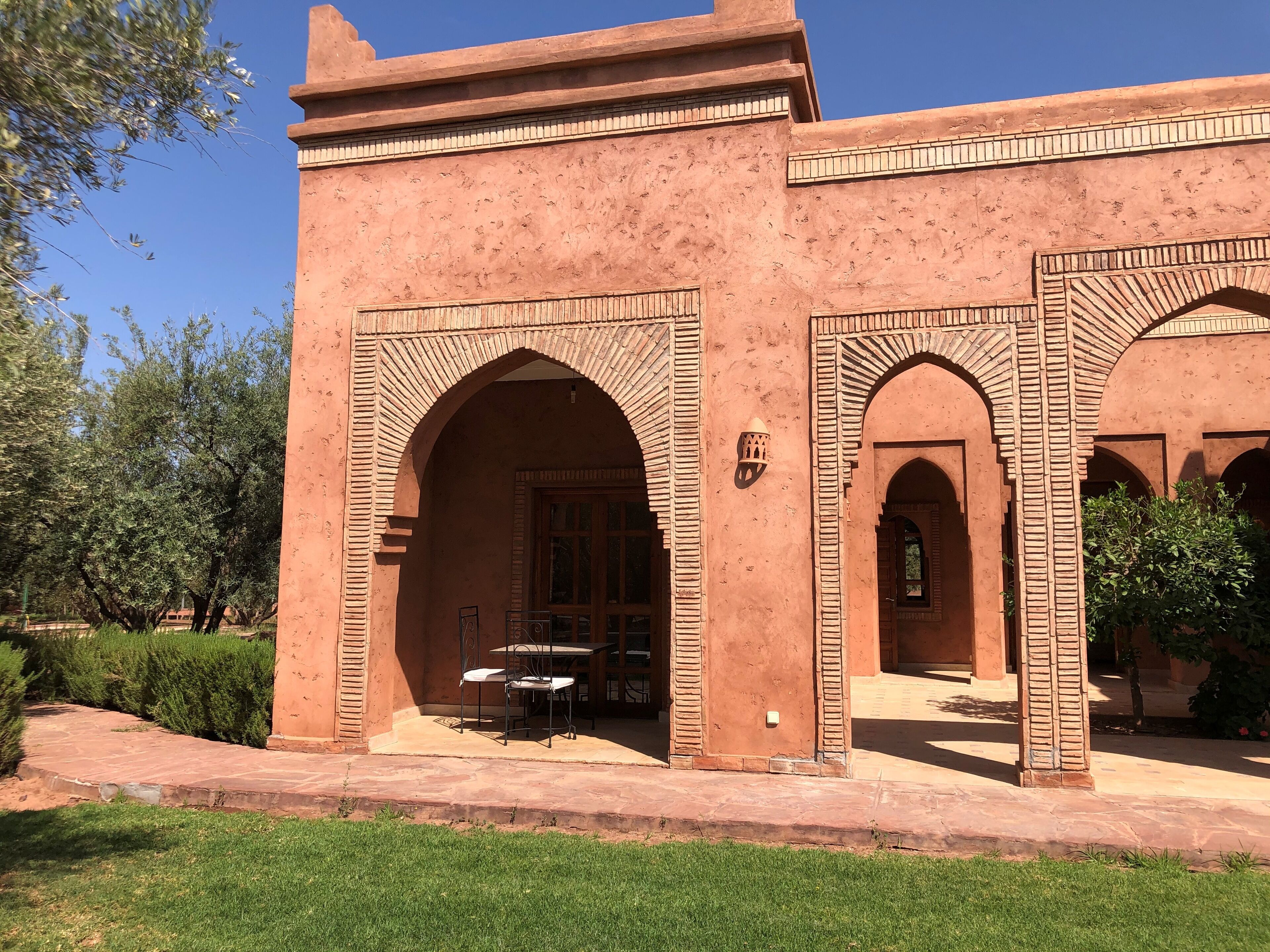 Un edificio con arcos y un patio cubierto con mesas al aire libre.