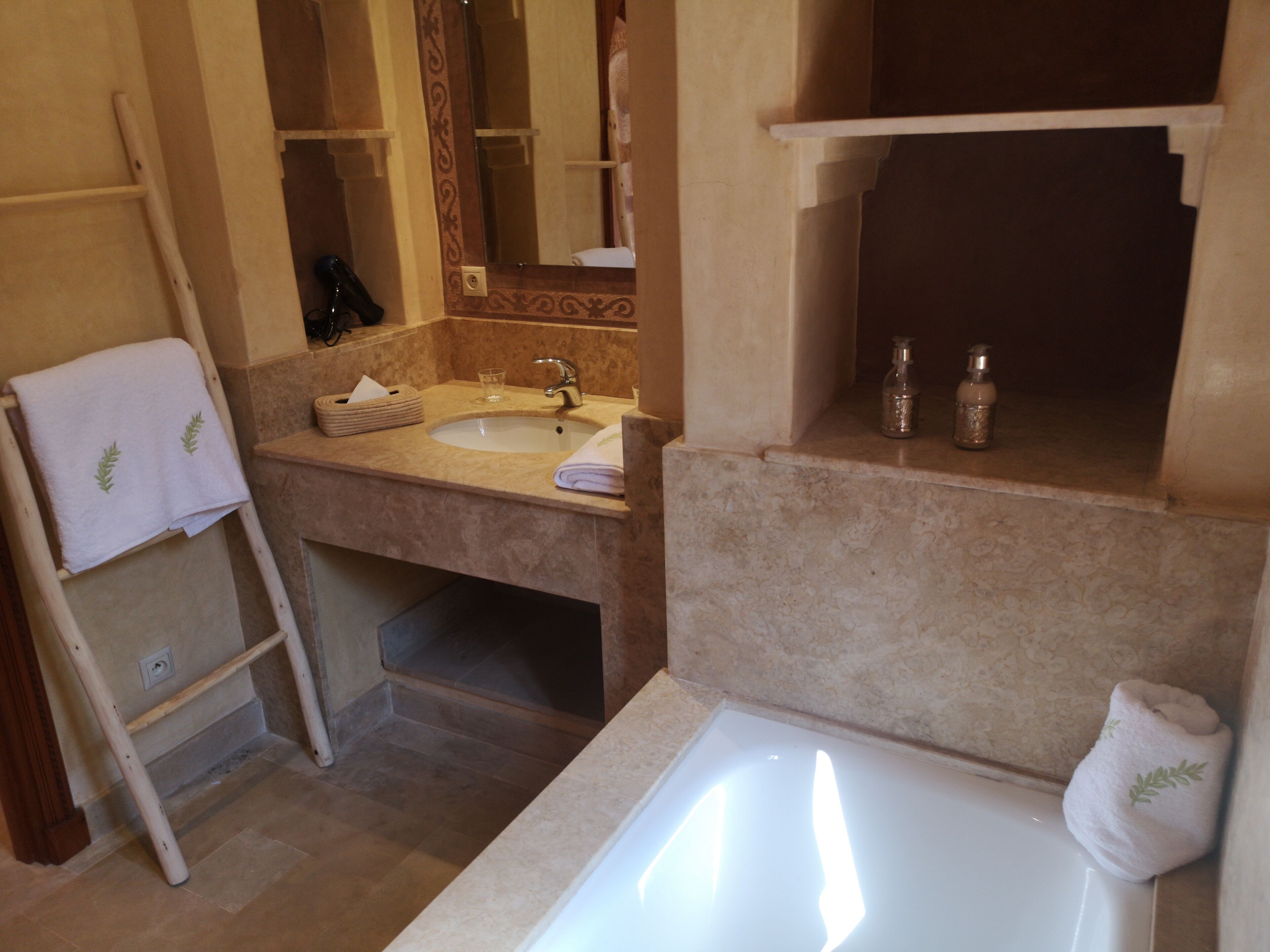 A bathroom with a bathtub, sink, and towel rack.