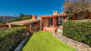A house with a stone pathway, a well-maintained lawn, and a view of the mountains.