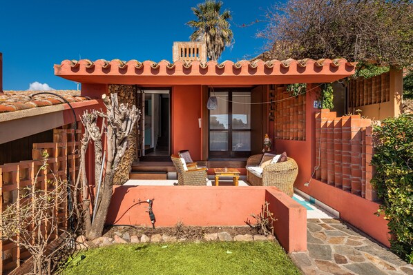 A house with a patio, outdoor seating, and a small pool.