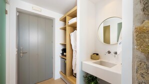 A bathroom with a sink, mirror, and wooden shelves. - Aegean Hospitality Mykonos (Mykonos)