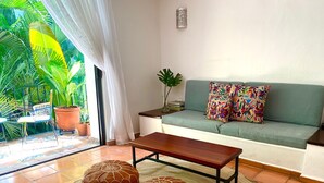 A living room with a sofa, colorful pillows, a coffee table, and two ottomans. - MARBELLA IN THE SPOTLIGHT, near the beach, for an effortlessly warm stay.  (Villa Las Flores)