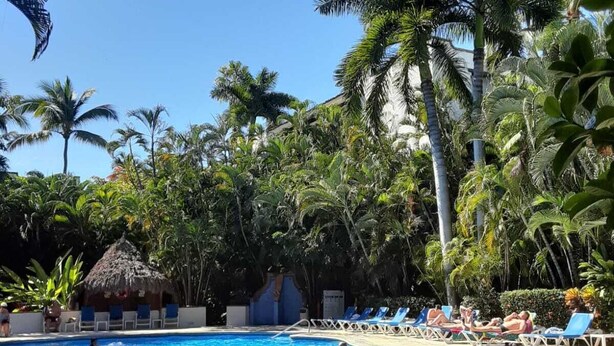 A swimming pool surrounded by palm trees and lounge chairs. - MARBELLA IN THE SPOTLIGHT, near the beach, for an effortlessly warm stay.  (Villa Las Flores)