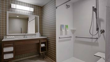 A modern bathroom with a shower, a sink, and a vanity.