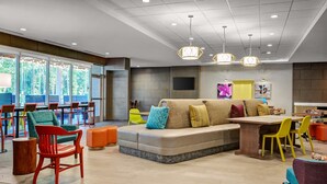 A modern lounge area with a sofa, chairs, a table, and pendant lighting. - Home2 Suites by Hilton Fort Mill, SC (Fort Mill)